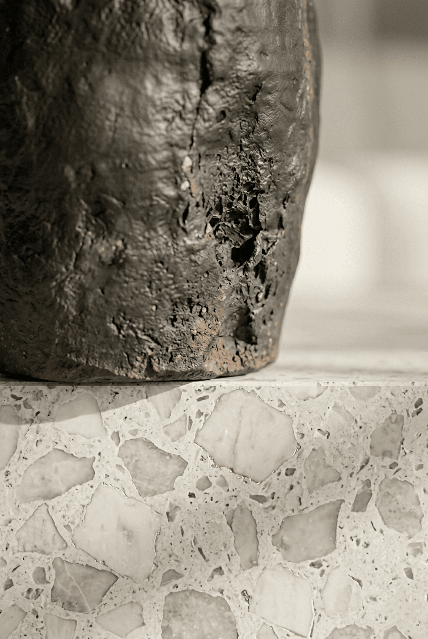 Macro detail of architectural joinery featuring a seamless intersection between matte smoked obsidian and warm, white ash wood grain.